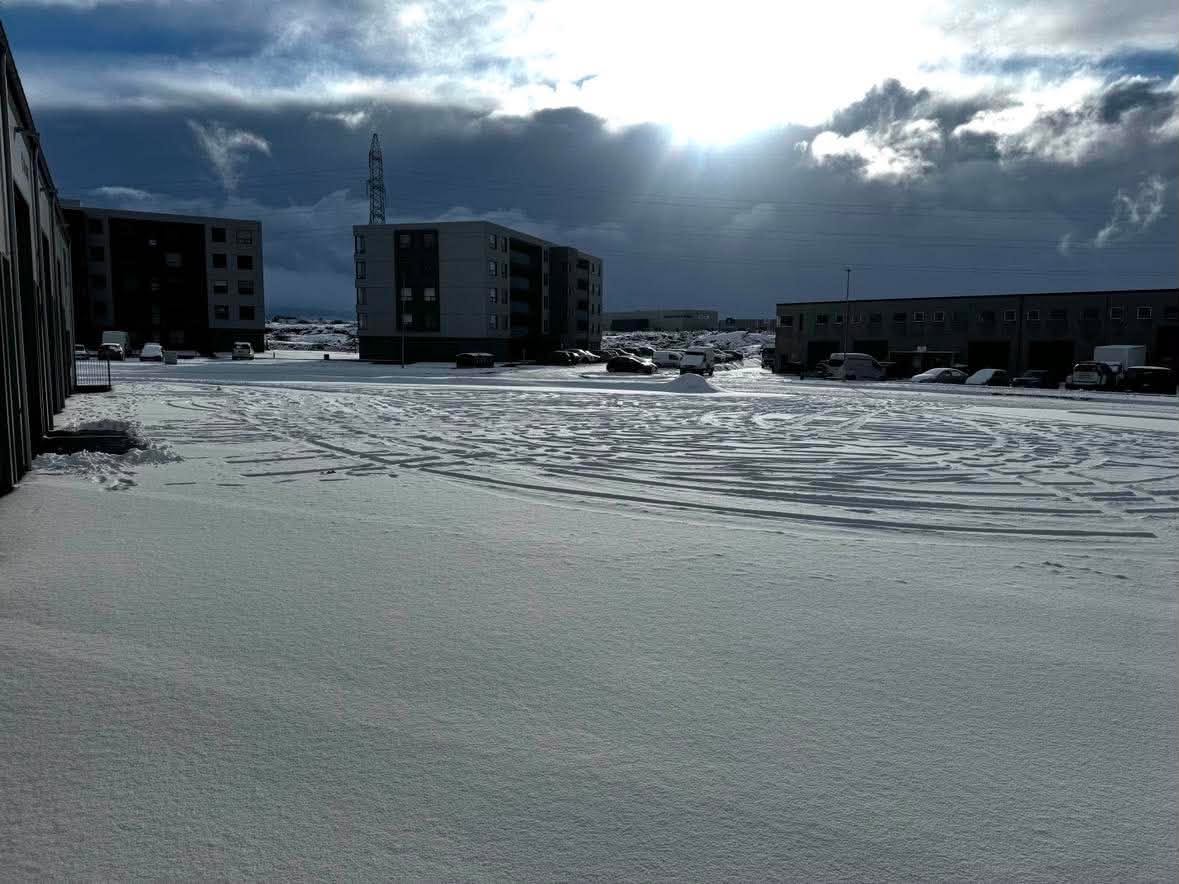 Bílaplan á kafi í snjó fyrir snjómokstur