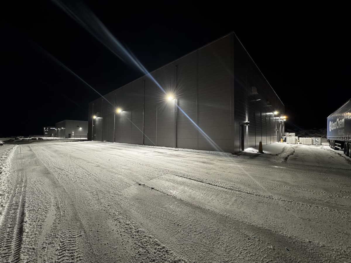 Nýmokað bílaplan við atvinnuhúsnæði að nóttu